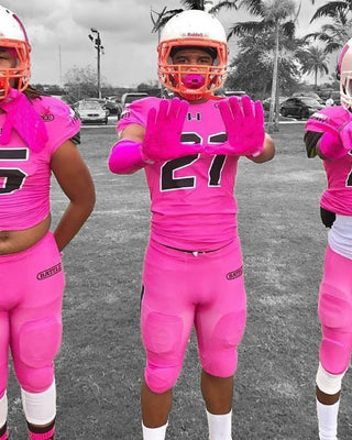 Football players wearing pink ribbon gear.