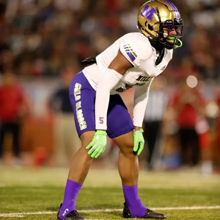 Football player wearing spats and compression arm sleeves