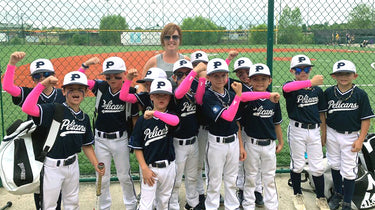 Team of baseball players wearing pink ribbon arm sleeves.