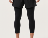 Person wearing black leggings and a gray top on a white background