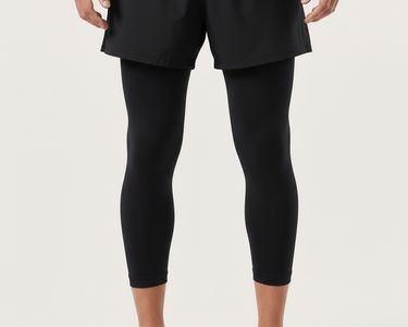 Person wearing black leggings and a gray top on a white background